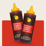 Two bottles of Momofuku Sweet & Spicy Korean BBQ Sauce on a red background