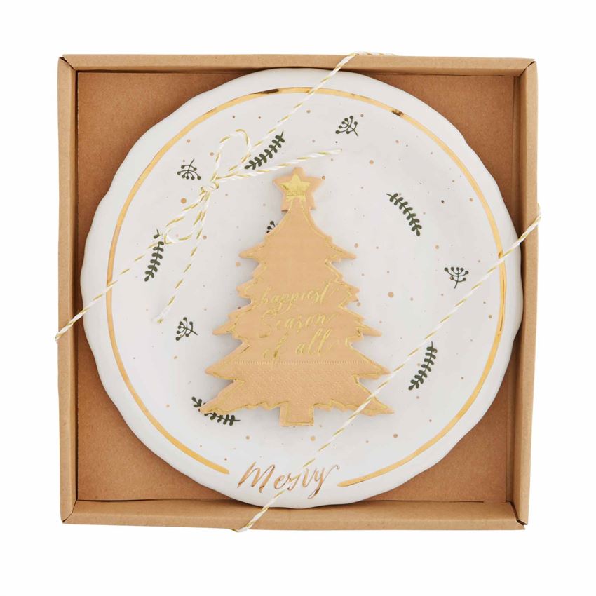 A white and gold cheese set is packaged in a cardboard box. The set includes a round ceramic plate with a Christmas tree motif and leaf patterns, along with a gold-plated cheese knife.