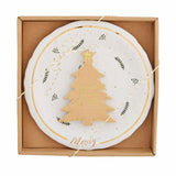 A white and gold cheese set is packaged in a cardboard box. The set includes a round ceramic plate with a Christmas tree motif and leaf patterns, along with a gold-plated cheese knife.