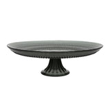 A large, round, black cake stand with a textured edge design.