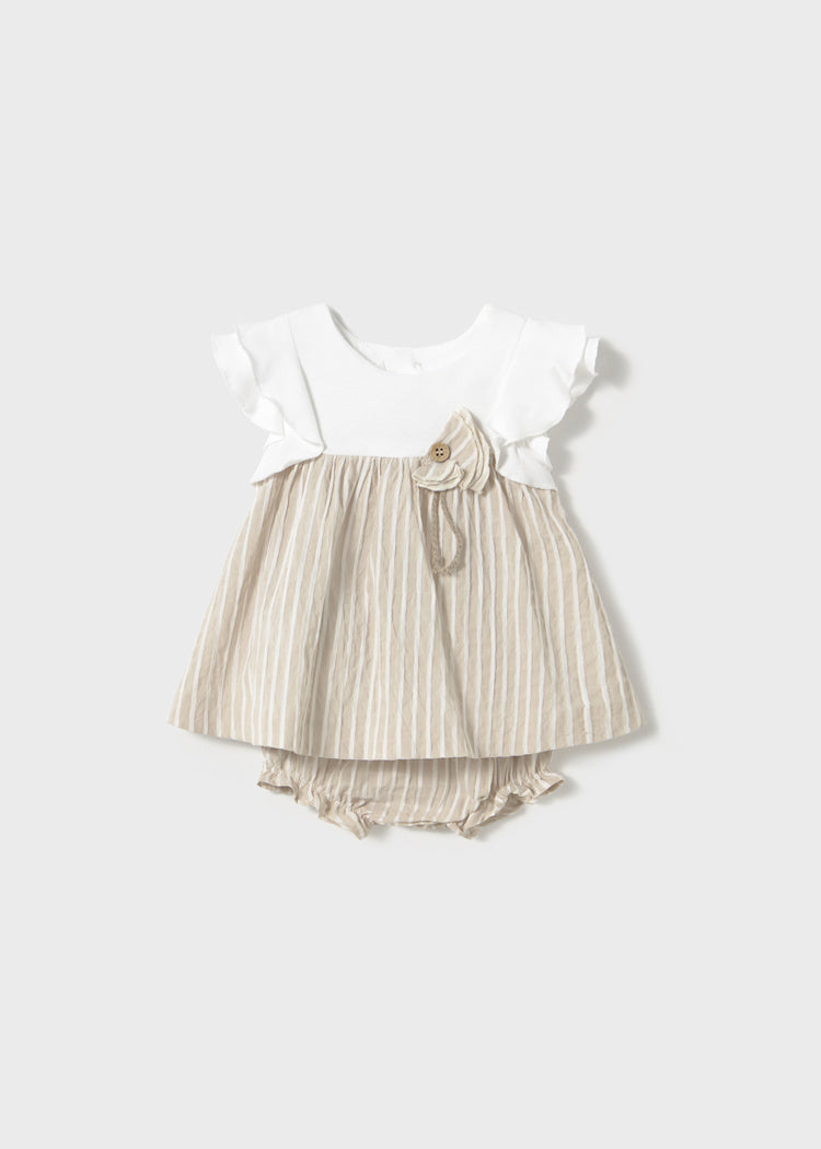 Baby outfit with white top and striped skirt on a plain background