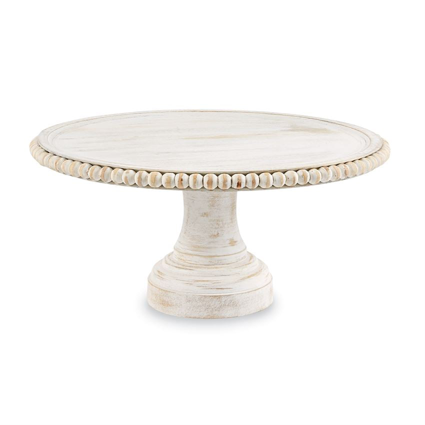 A white beaded cake stand with a round top and a pedestal base.