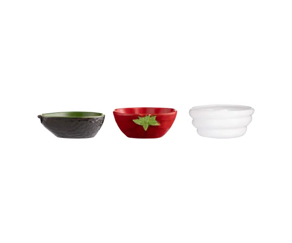 A set of three ceramic bowls in shapes of an avocado, tomato, and sour cream, each with a decorative element (such as a leaf or dot pattern) in their respective colors (green, red, and white).