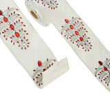 A spool of white wired ribbon with a jeweled tree pattern, featuring red and clear embellishments.