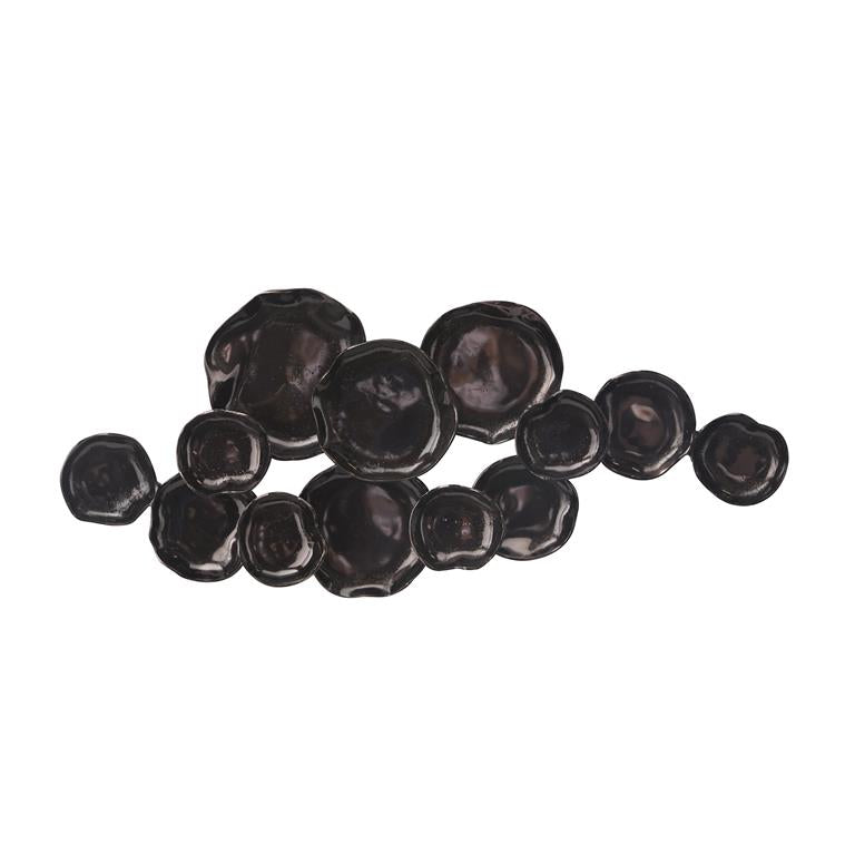 A wall decor made of black and dark gray spherical objects of varying sizes arranged unevenly on a white background.