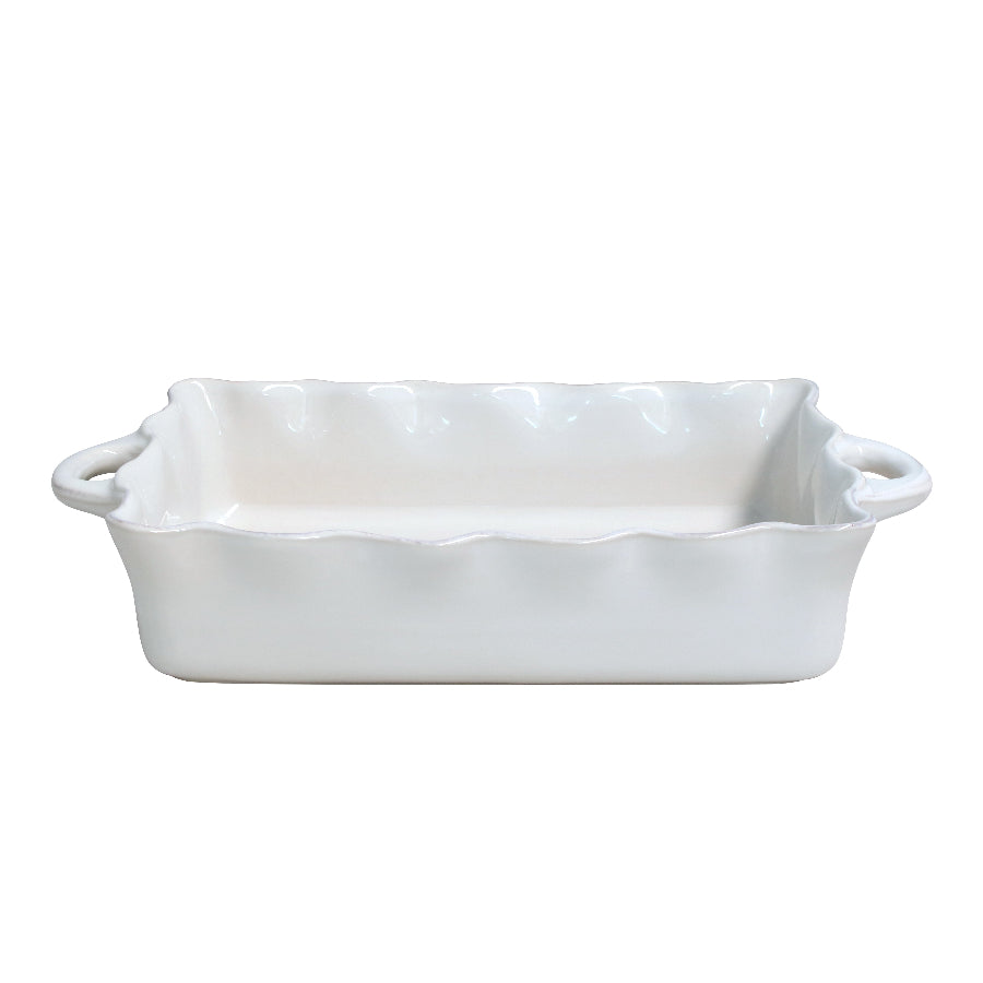 A white rectangular ceramic baker with ruffled edges and small handles on the sides.
