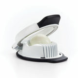 An OXO Good Grips Egg Slicer in white color with a black top lever, shown with an egg being sliced, placed against a white background.