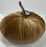A decorative orange velvet pumpkin with a realistic stem on a white background.
