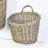 A brown wicker pocket basket with a handle, set against a white background.