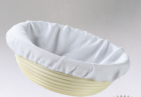 A white round bread proofing liner placed inside a basket, likely made of cloth material.