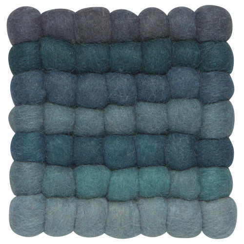 A trivet with a dot ombre design featuring shades of blue and green.