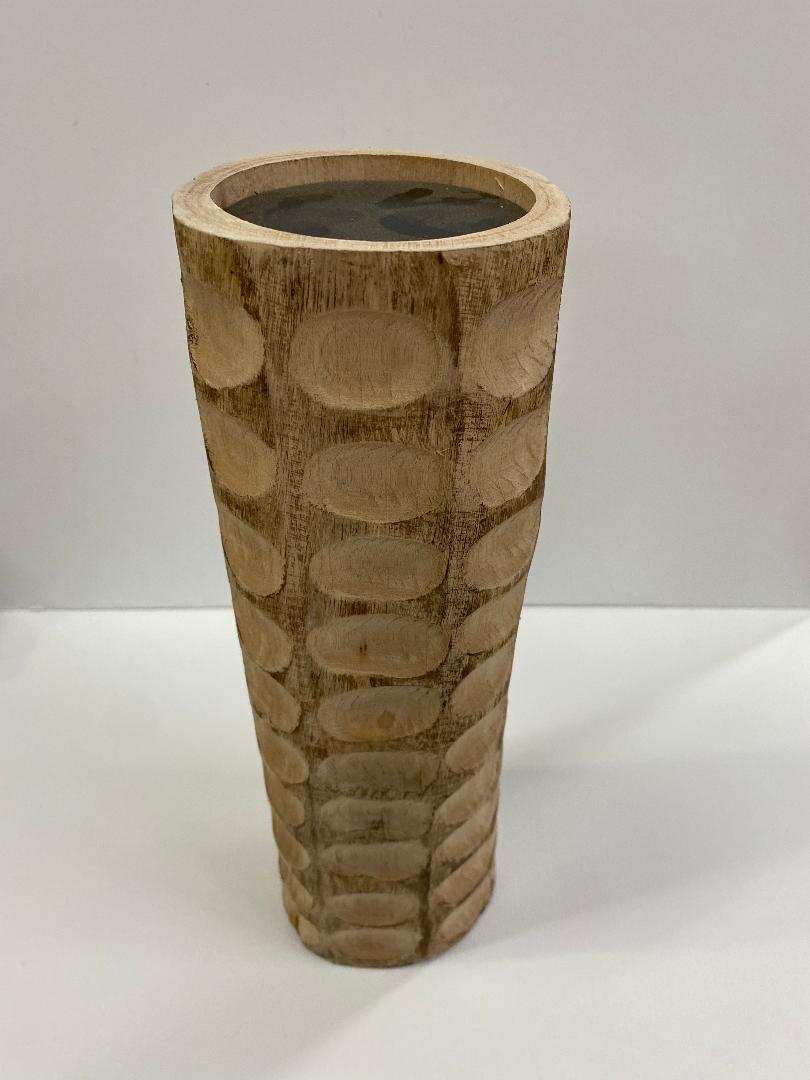 A chiseled wood candle holder with a geometric pattern, displaying a natural wood color.