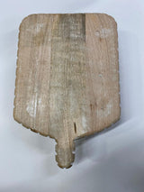 A beige-colored LG carved wood serving board with a natural wood pattern and a handle.