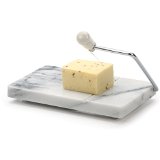 A marble cheese slicer with a piece of cheese on it, featuring a stainless steel blade and a white handle.