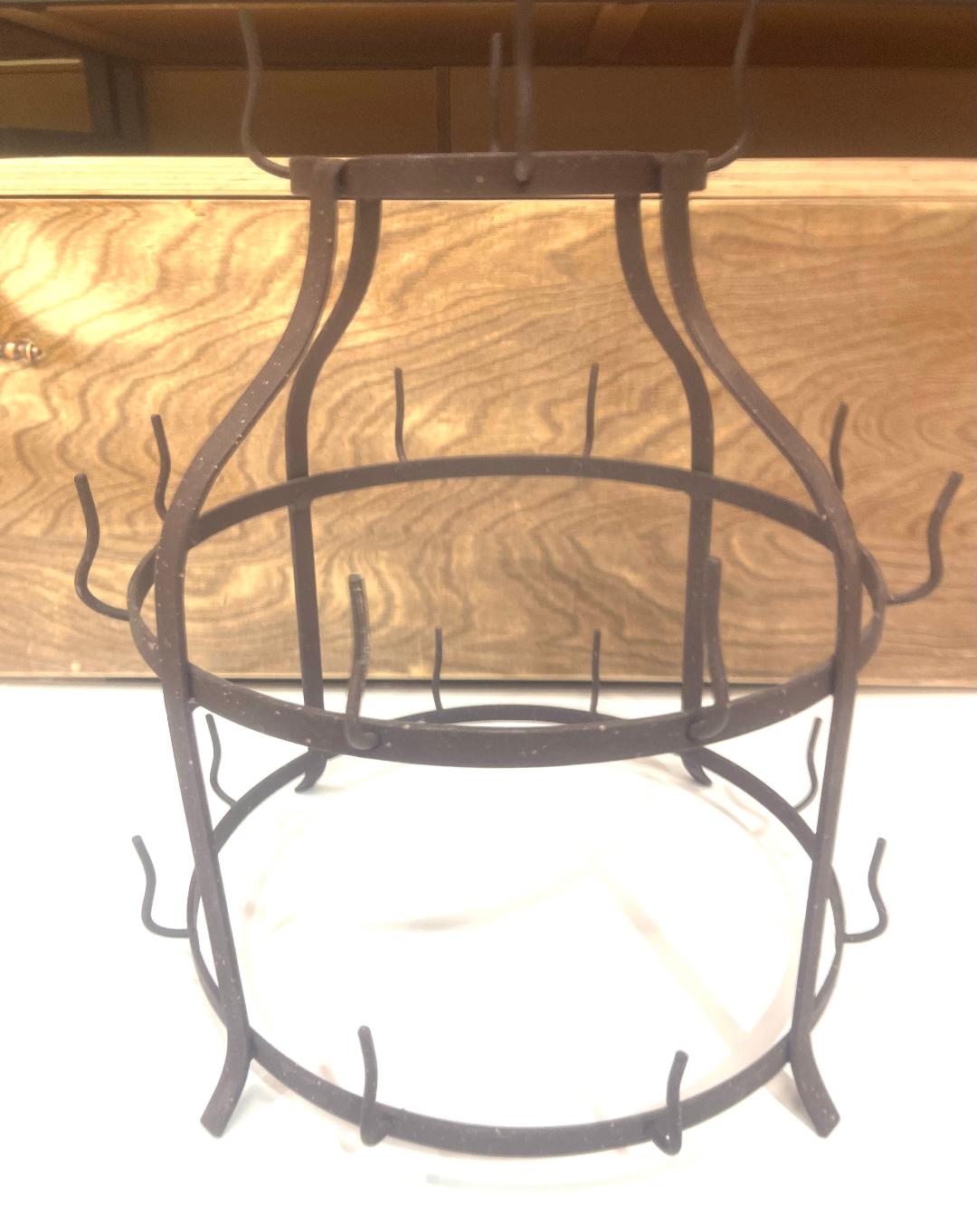 A wall-mounted metal mug holder with multiple hooks, primarily brown in color, designed to organize mugs on a kitchen wall.