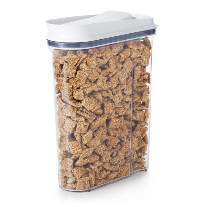 A clear plastic cereal dispenser with a white lid, filled with dry cereal.