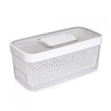 A white OXO Producer Keeper 5QT with a clear front, showing the carbon filter and the removable basket inside.