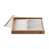 A set of eight silver stainless steel steak knives with plastic handles, displayed in an open wooden box with a clear cover.