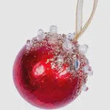 Red Christmas ornament with glitter on a white background