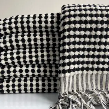 A stack of multicolored hand towels with a geometric pattern.