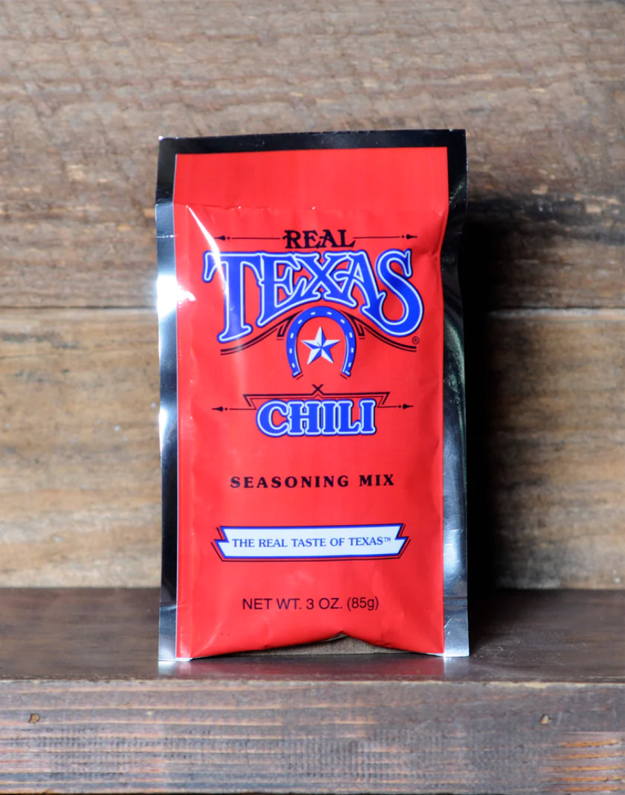 A package of Bear Creek Smokehouse Real Texas Chili Mix against a wooden background.