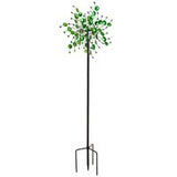 A tall metal wind spinner with a botanical design, featuring green leaves, intended for outdoor use.