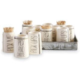 A set of ceramic toothpick holders with various texts on them, displayed in a metal tray.