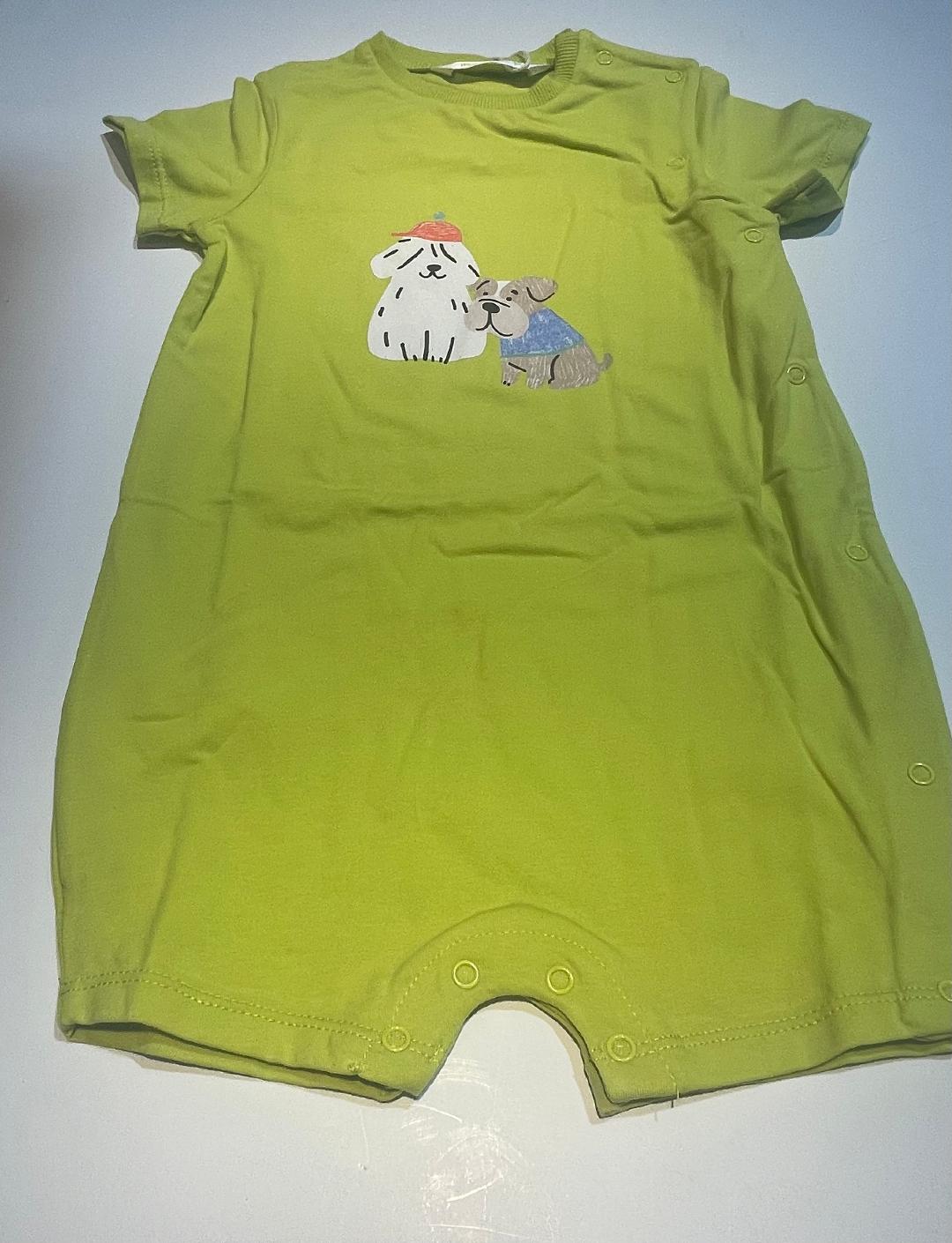 A green baby romper with a graphic print of a dog and a cat on the front.