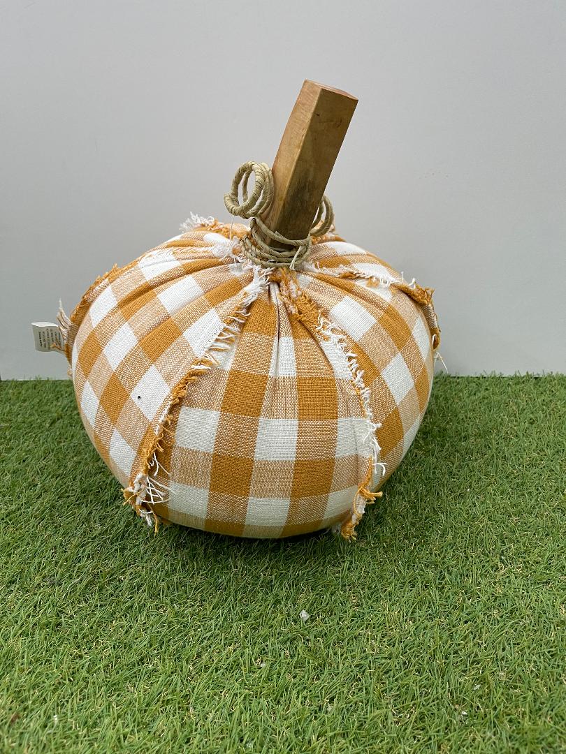 Decorative pumpkin with checkered pattern on a grassy surface
