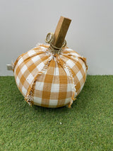 Decorative pumpkin with checkered pattern on a grassy surface