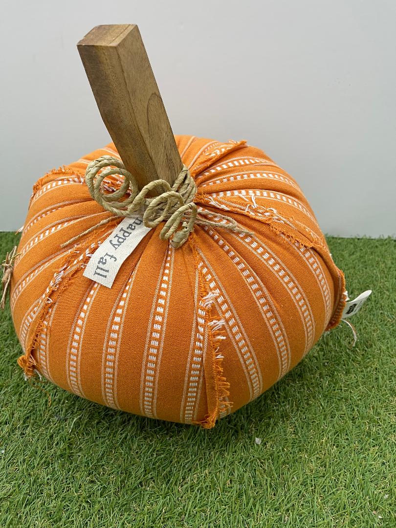 Decorative pumpkin with a wooden handle on a grassy surface