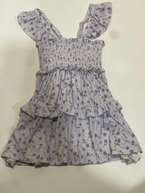 A toddler-sized dress with a floral pattern, short sleeves, and a round neckline.