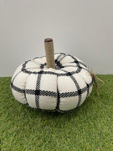 Decorative pumpkin with black and white plaid pattern on grass