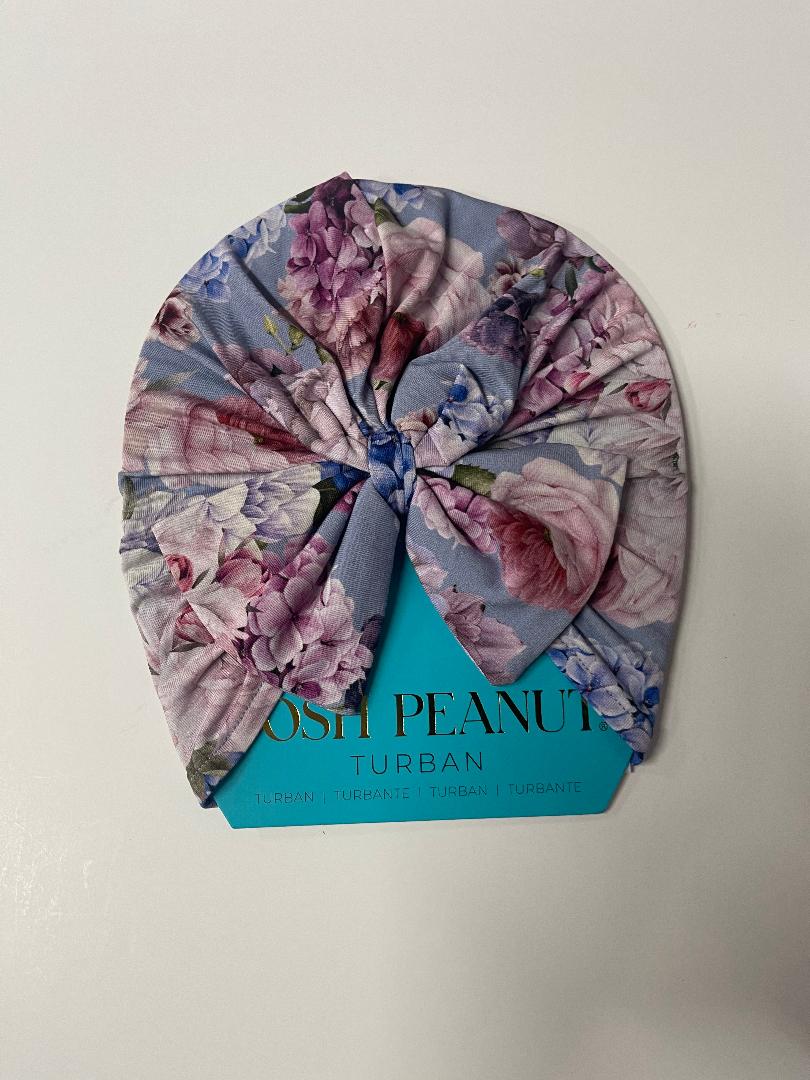 A floral-patterned turban hat with a label that reads 'POSH PEANUT URBAN'.