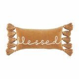 A rectangular velvet throw pillow with the word 'blessed' written on it, adorned with tassels on the sides.