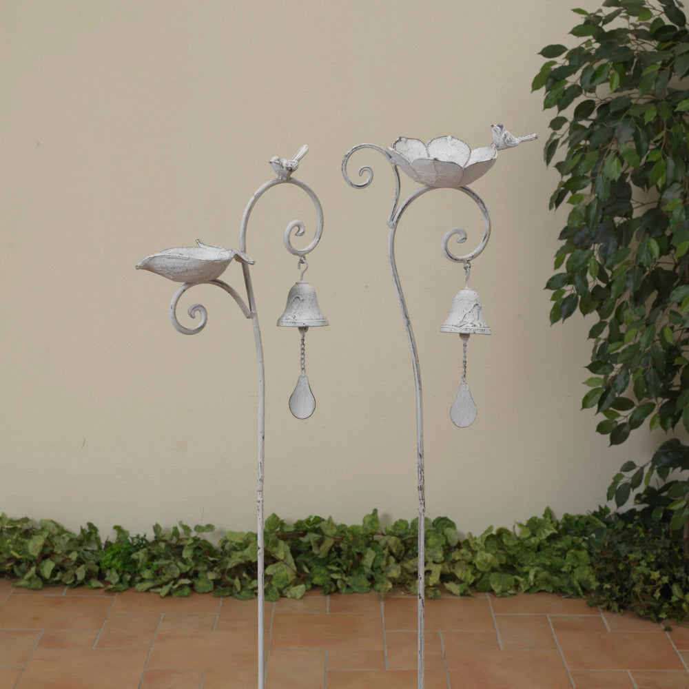 A silver cast iron birdbath with decorative elements, displayed outdoors.
