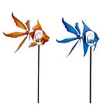 Two solar-powered fish-shaped wind spinners in orange and blue colors, designed to be placed in garden or patio spaces.
