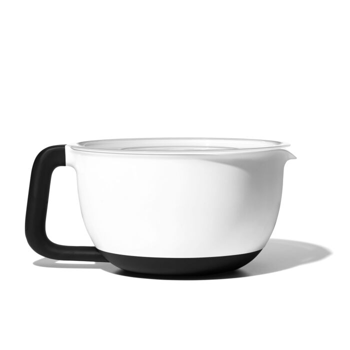 A white OXO GG batter bowl with a black lid and handle, isolated on a white background.