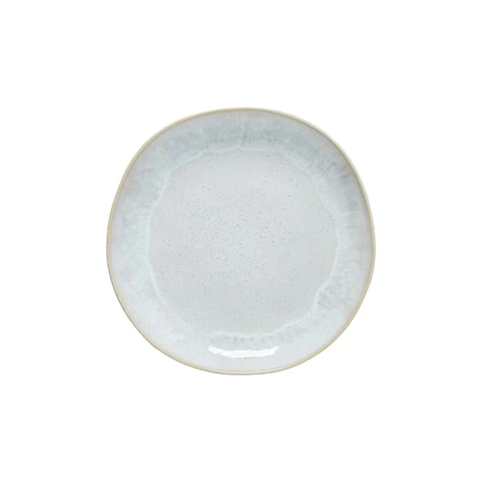 A round, white ceramic salad plate with a textured edge.