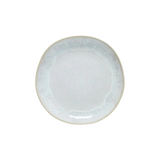 A round, white ceramic salad plate with a textured edge.