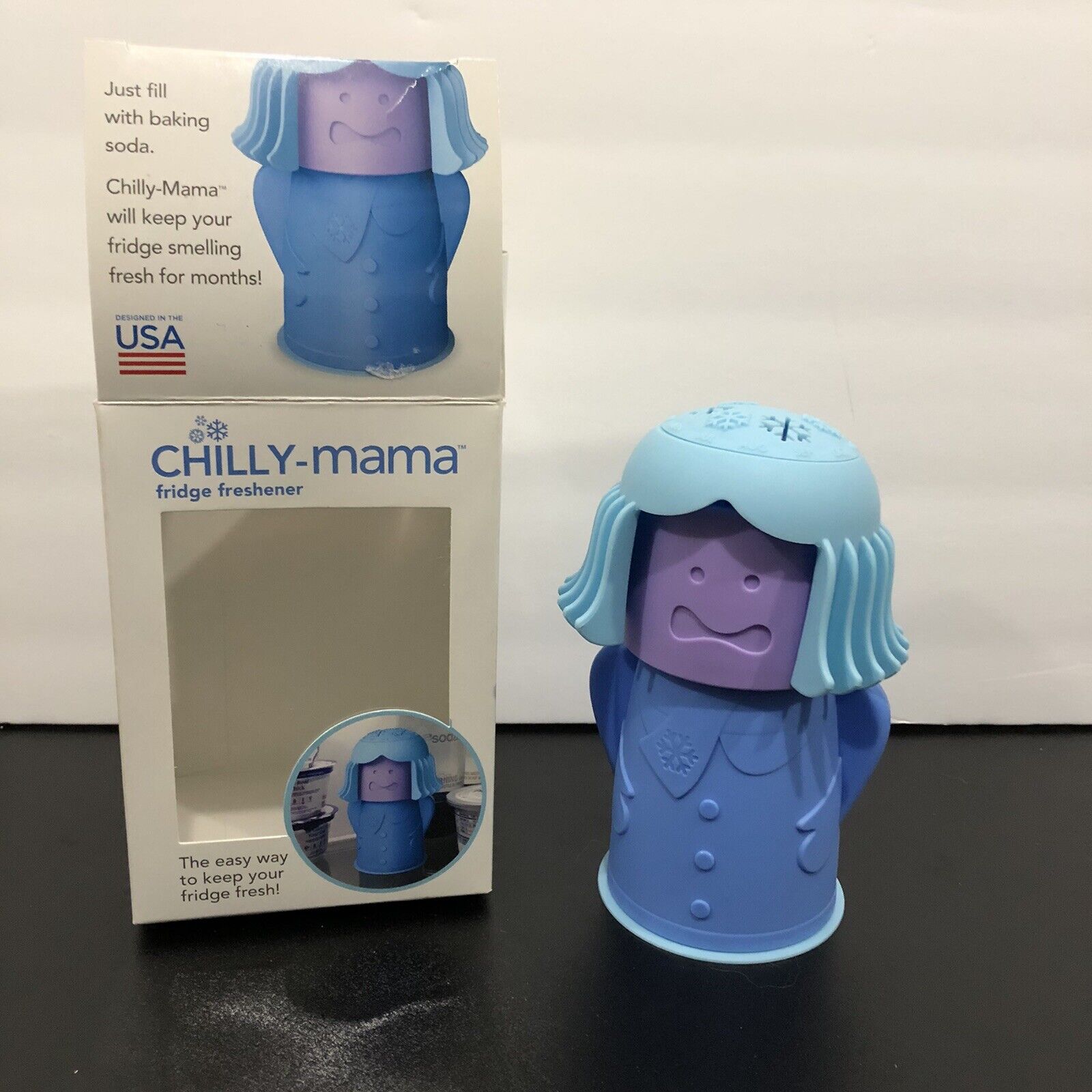 A Chilly Mama Fridge Freshener in the shape of a cartoon character. The product is blue with a lighter blue outfit and is displayed with its packaging.