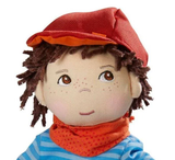 A doll with brown hair, red hat, and blue and white striped shirt.