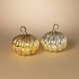 Two pumpkin-shaped lighted mercury glass decorations, one with a gold finish and the other with a silver finish, set against a neutral background.