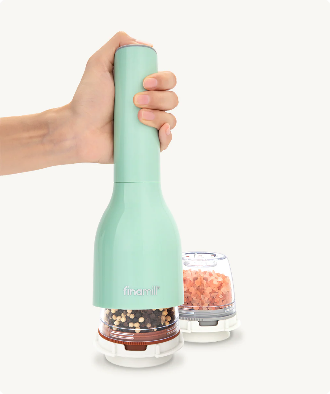 Mint green pepper grinder held by a hand with a white background