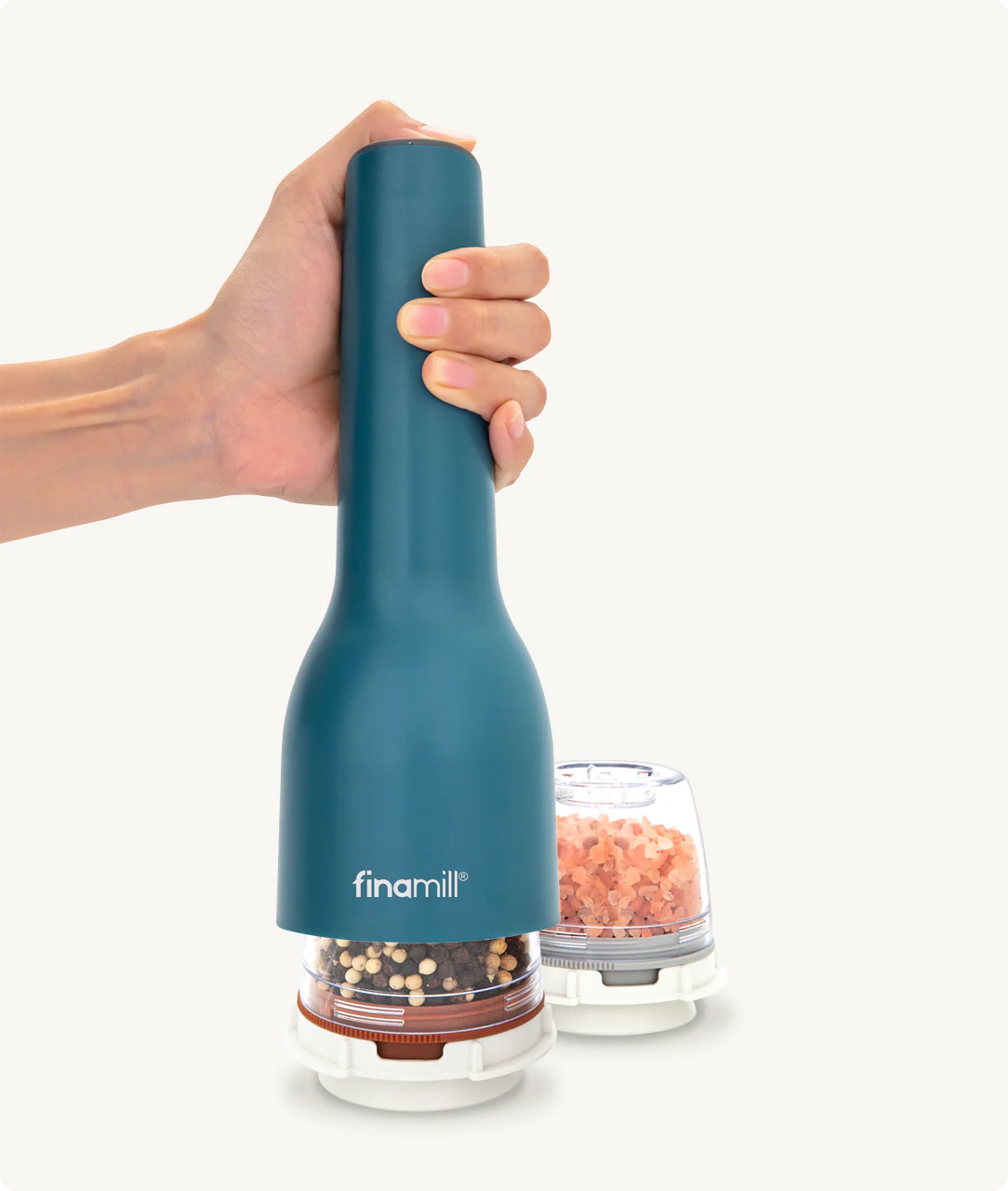 Hand holding a teal pepper grinder with 'finamill' branding on a white background