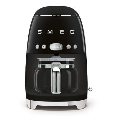 A green SMEG drip filter coffee machine with a glass carafe and stainless steel accents.