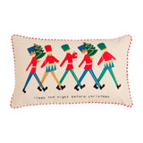 A decorative pillow with an illustration of nutcrackers in red and green uniforms on a beige background with the text 'it was the night before Christmas'. The pillow has a red trim.