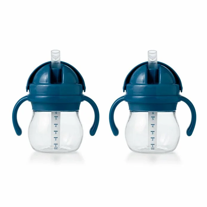 Two blue OXO TOT straw cups with handles and measurement markings on the side.
