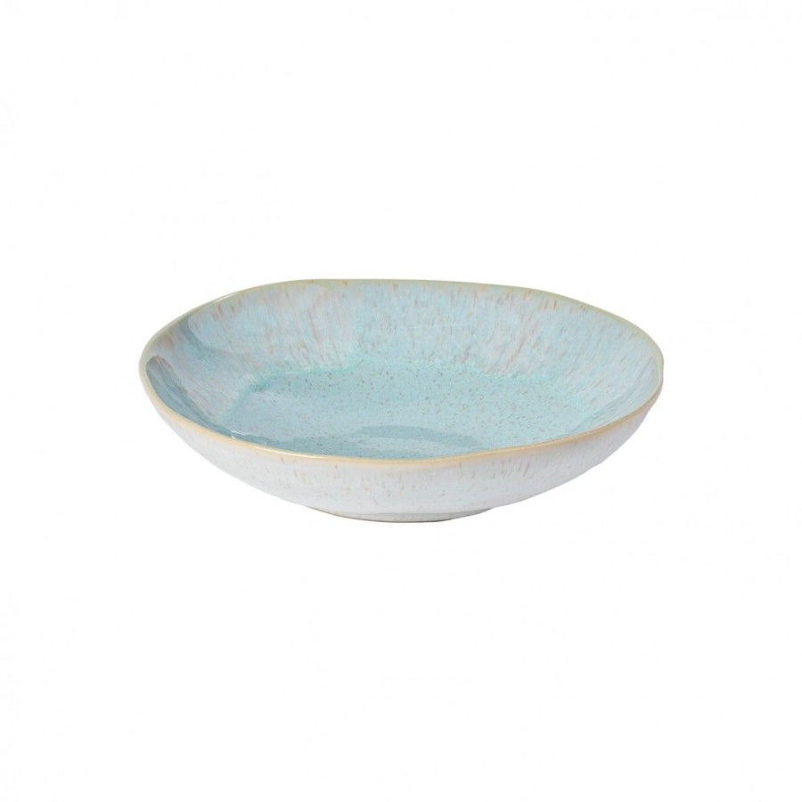 A ceramic pasta bowl with a blue exterior and beige interior.