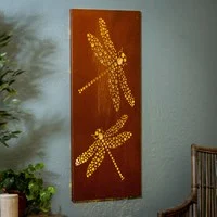 A brown wooden wall decor featuring laser cut silhouettes of dragonflies hanging on a wall.